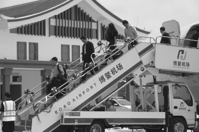昨天，旅客从抵达博鳌机场的首航班机走下。博鳌机场实现试运行，将服务博鳌论坛2016年年会。新华社发